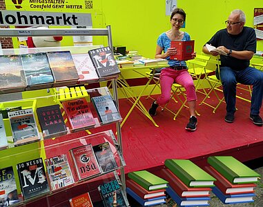 Frau Dilkaute (Stadtbücherei Coesfeld) und Dieter Niehoff (Mitgleid des Fördervereins) präsentieren eine Auswahl der angebotenen Flohmarktbücher.